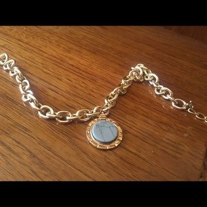 Gold necklace with blue stone in the middle